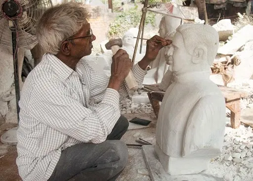 Artisan carving a marble sculpture